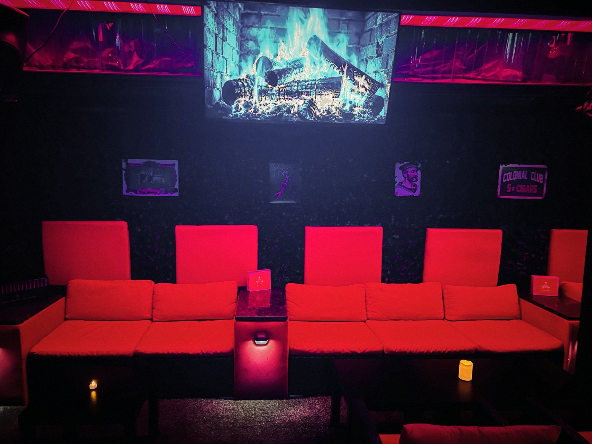 Red sofas facing a fireplace screen