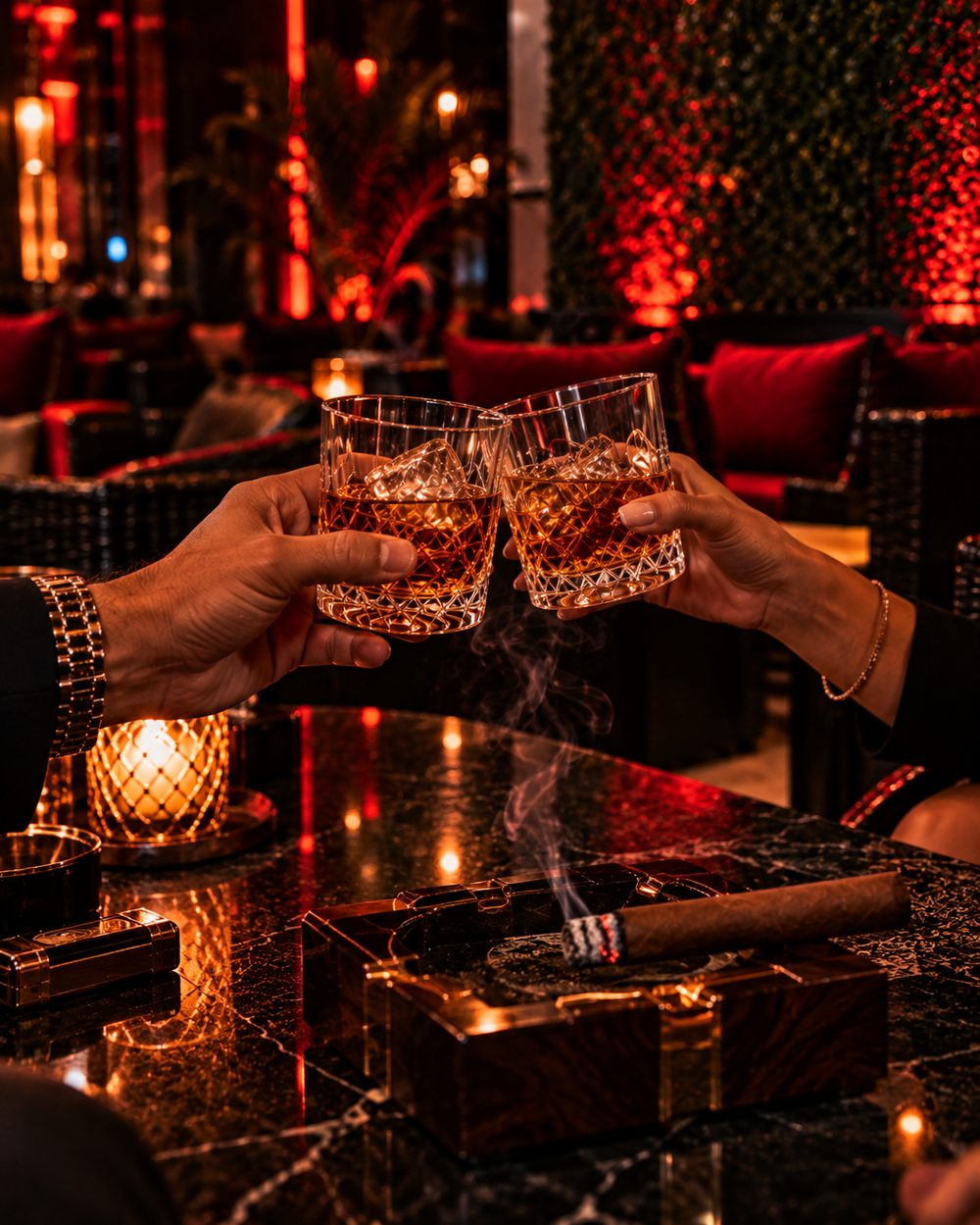 Two glasses raised in a toast over a smoking cigar